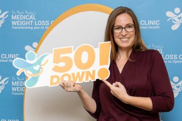 Woman holding 50 pounds down sign